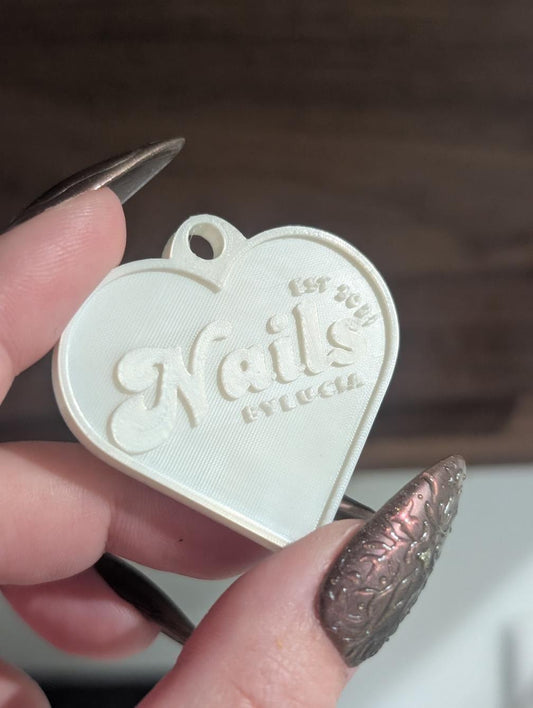 a custom nfc keychain for nails by lucia in a pearl silk heart shape.